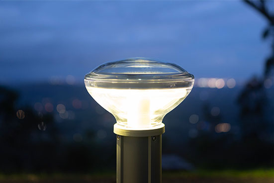 Solar bollard lights illuminating an outdoor pathway at night using renewable solar energy