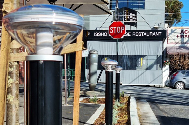 Solar bollard lights installed near street corner in urban outdoor setting