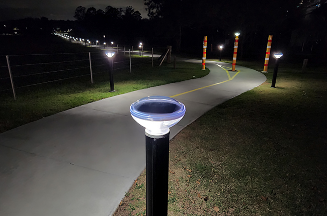 Solar bollard light illuminating pathway at night for safe outdoor navigation